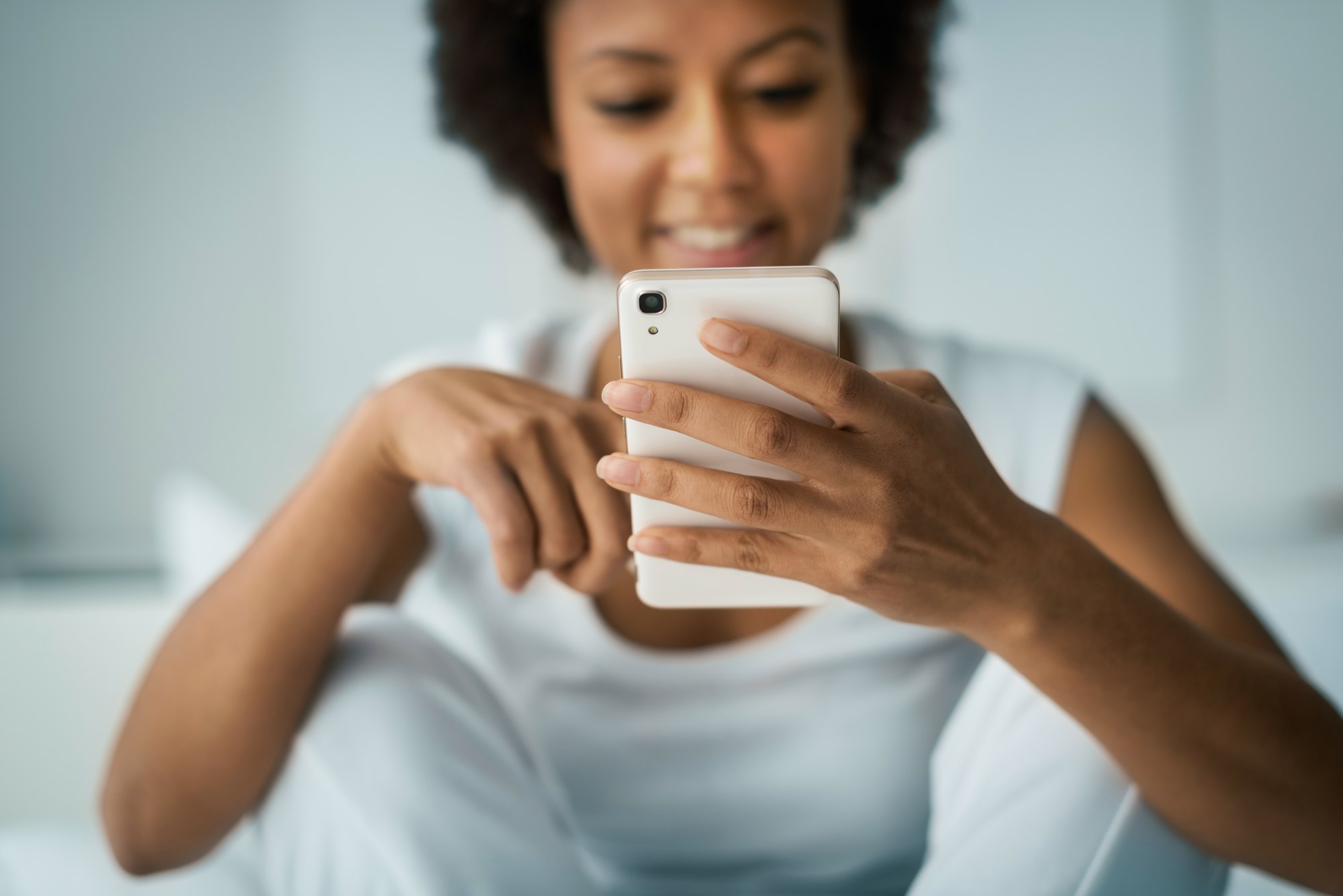Woman texting and smiling at iphone