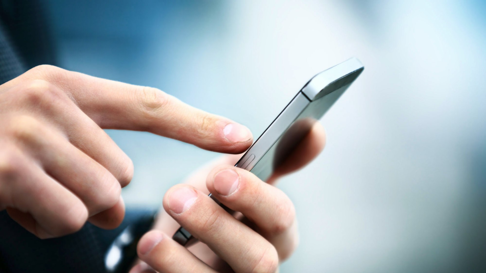Male hand touching mobile phone