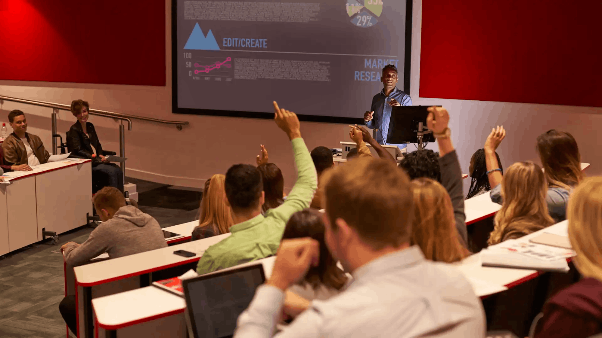 Students at a lecture raising hand