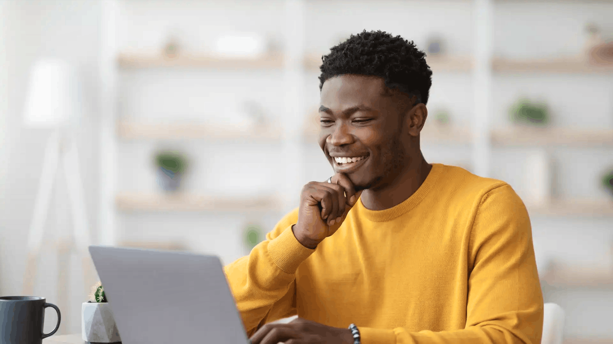 man smiling whilst working on lapop