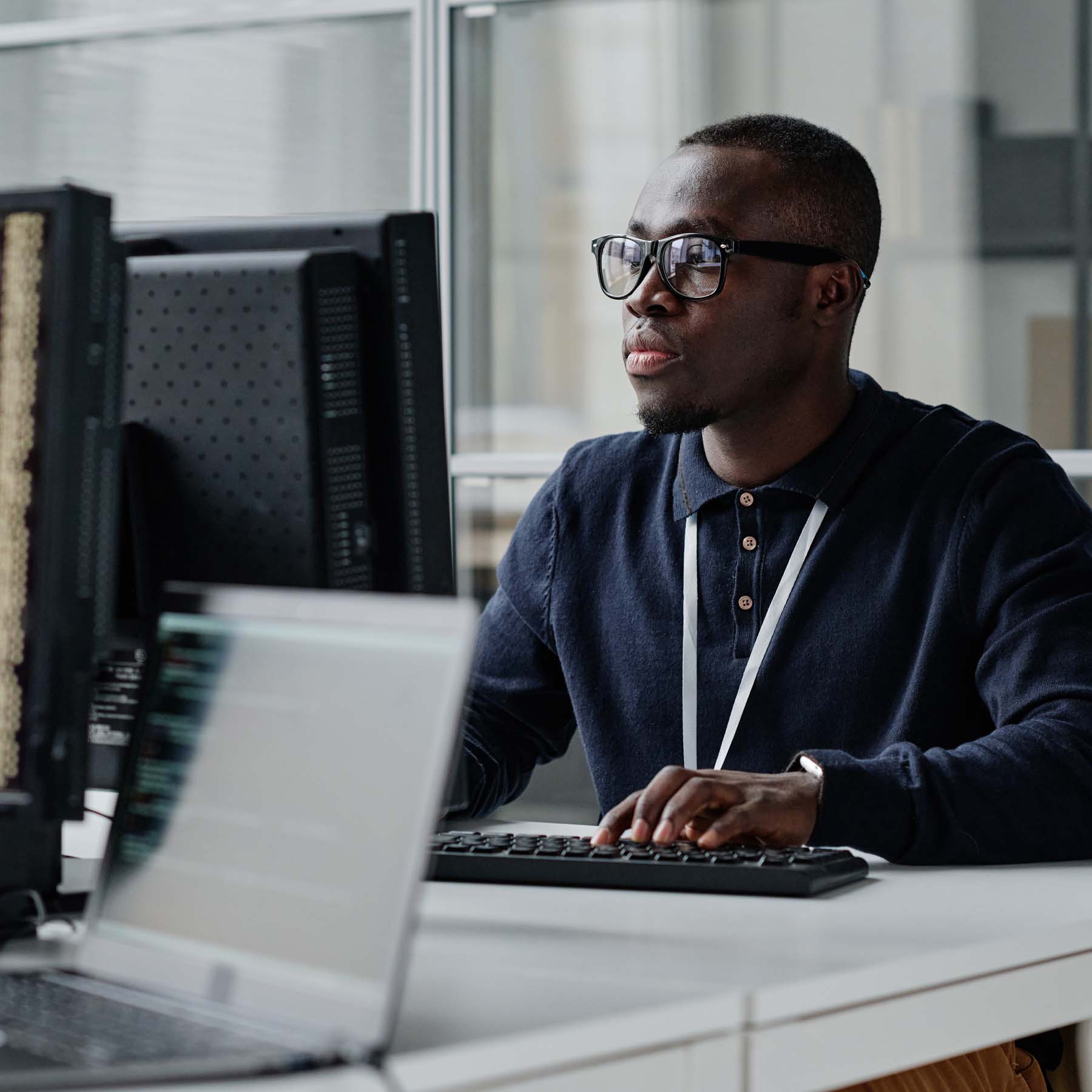 Male worker at desk with lanyard