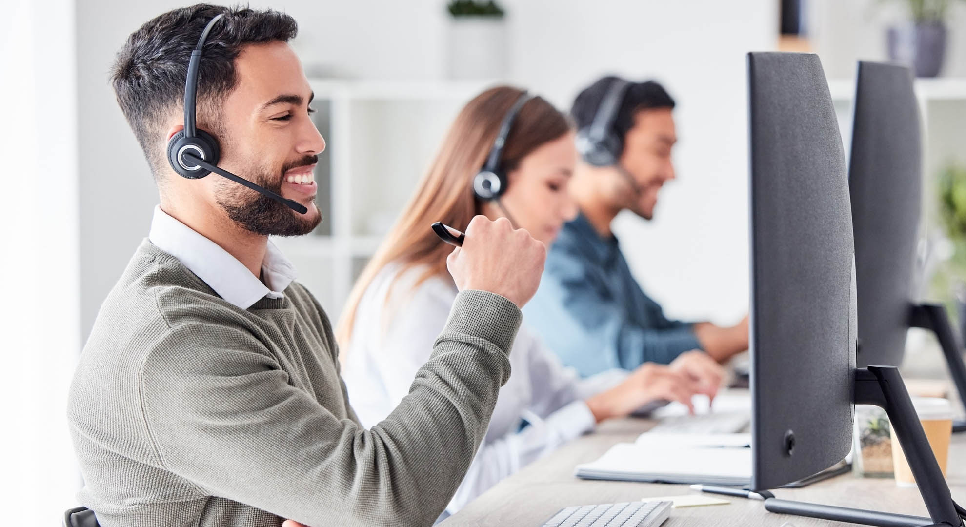 Contact centre colleagues smiling with headphones on