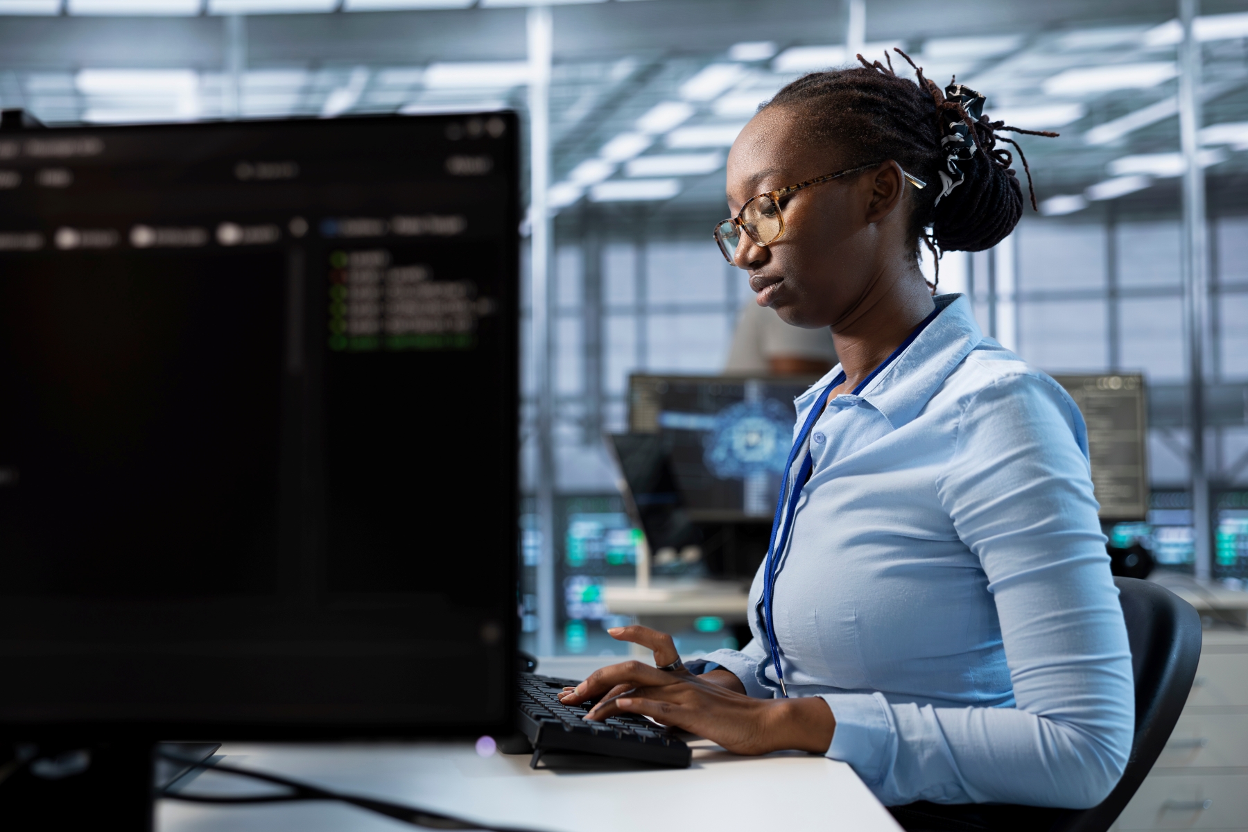 Woman sitting at desk typing on computer
