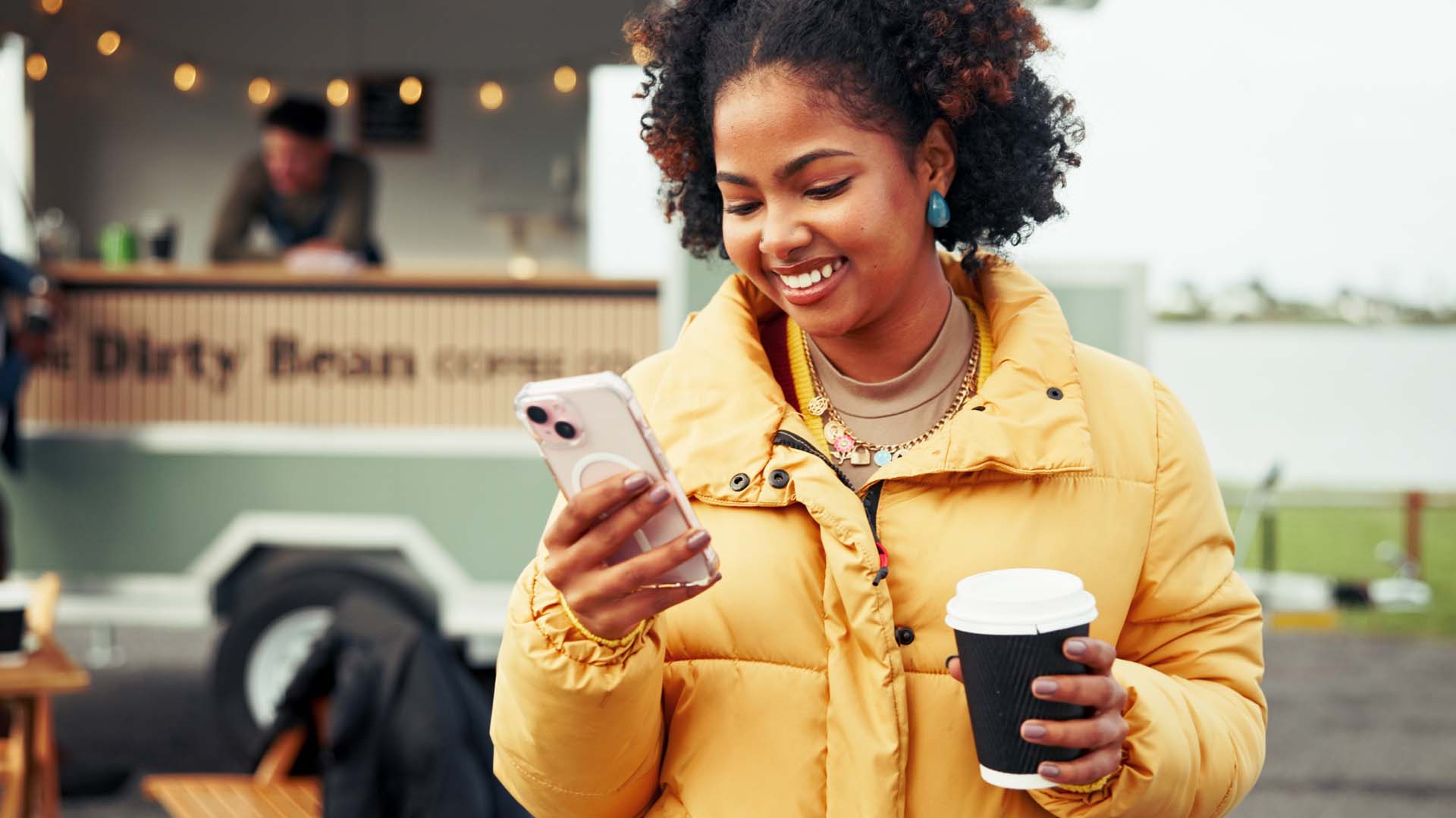 Woman on phone with coffee smiling