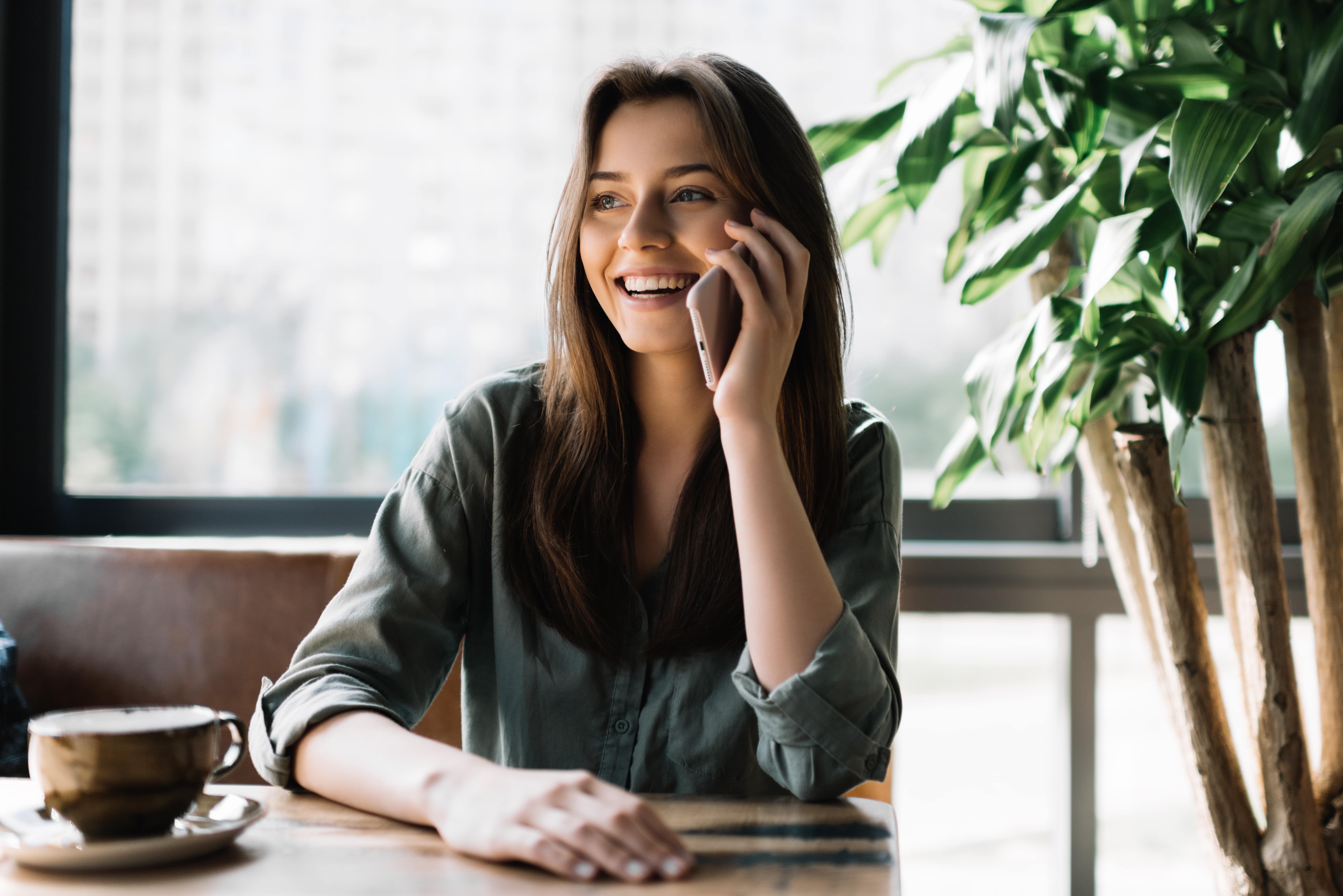 Woman on mobile phone smiling at home