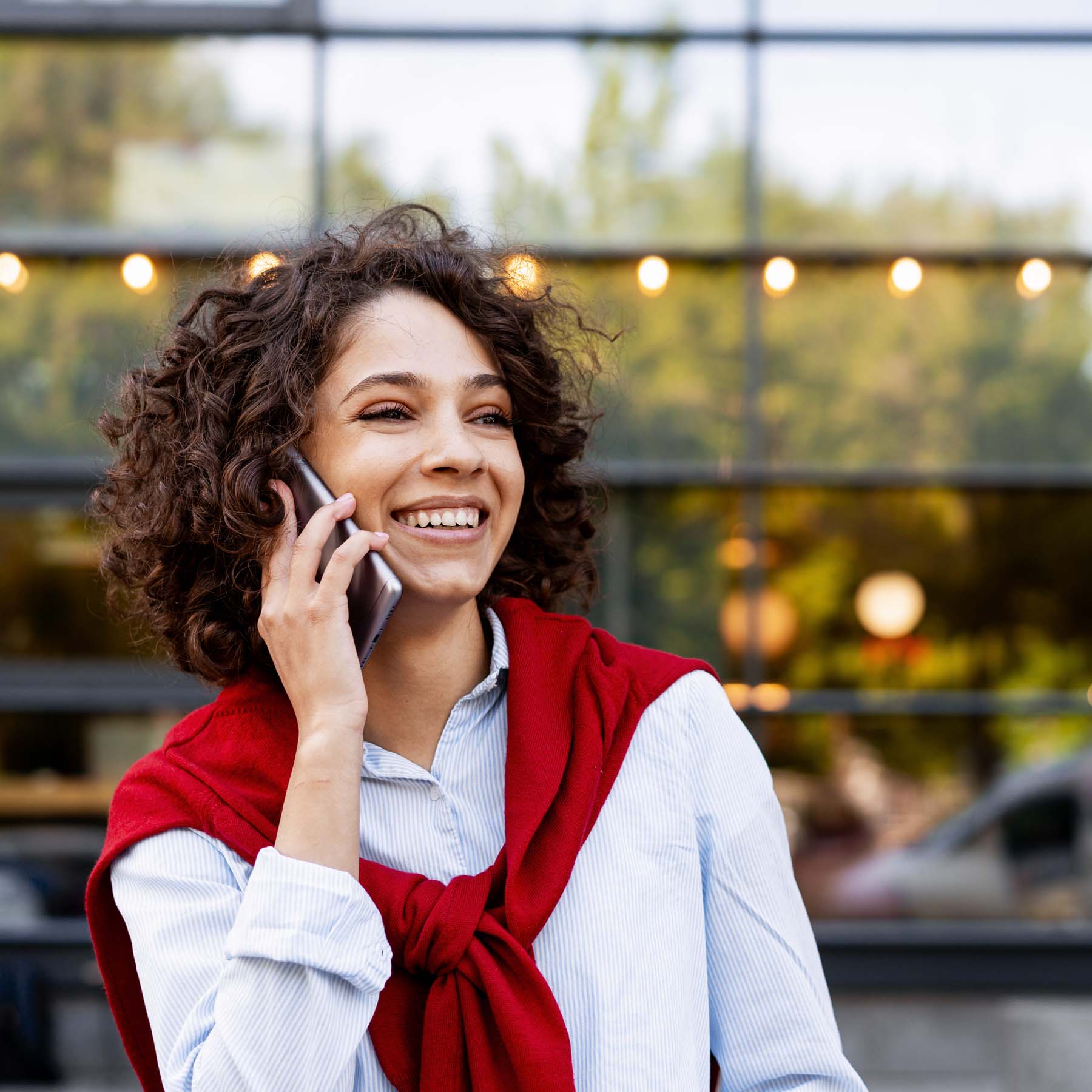 Woman on phone with red jumper smiling
