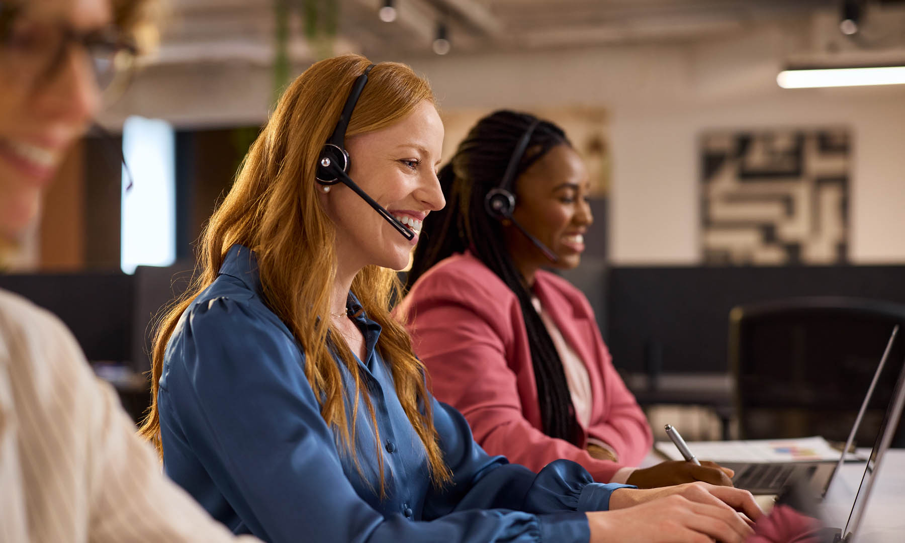Colleagues working in call centre with headphones on