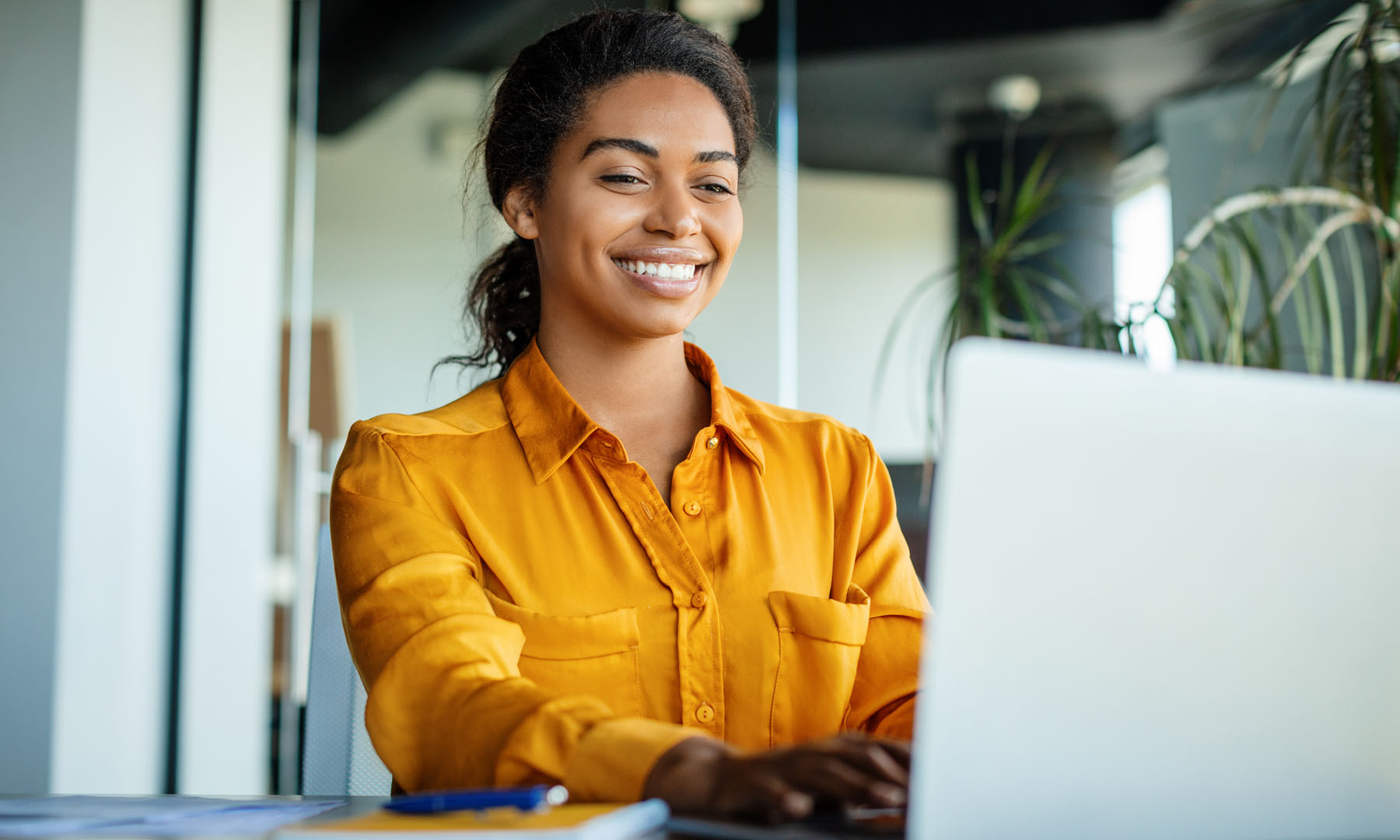 Woman on laptop smiling whilst working