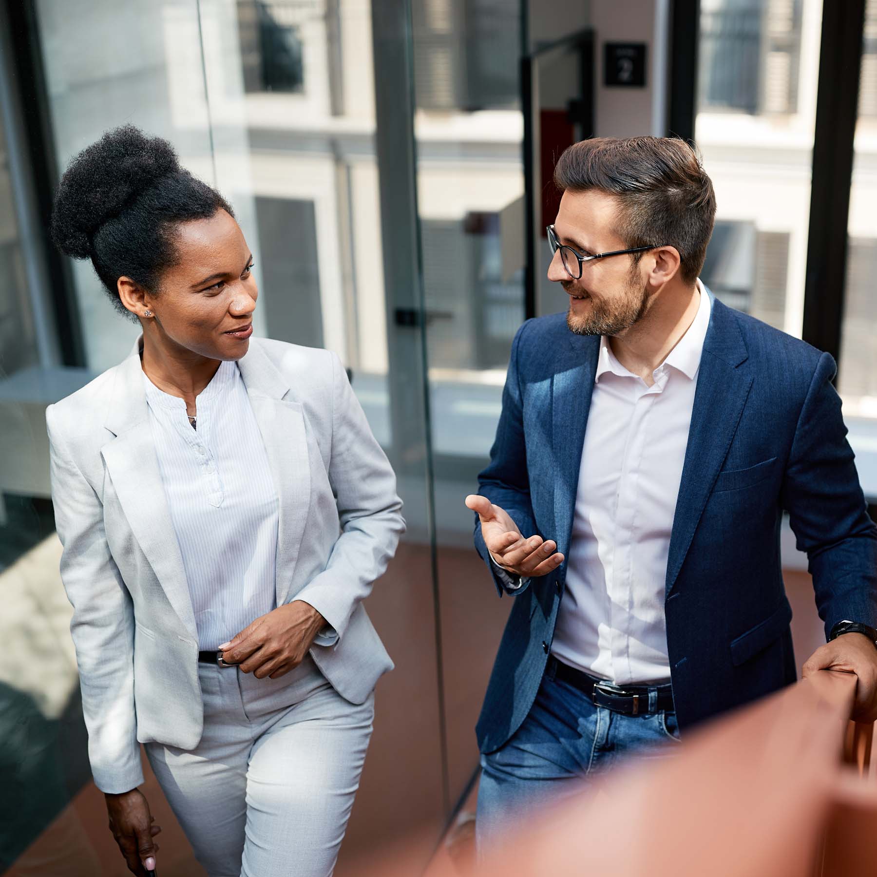 Male and female colleague walking and talking