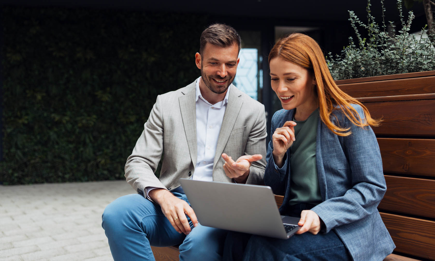man and woman coworker sitting on bench with tablets