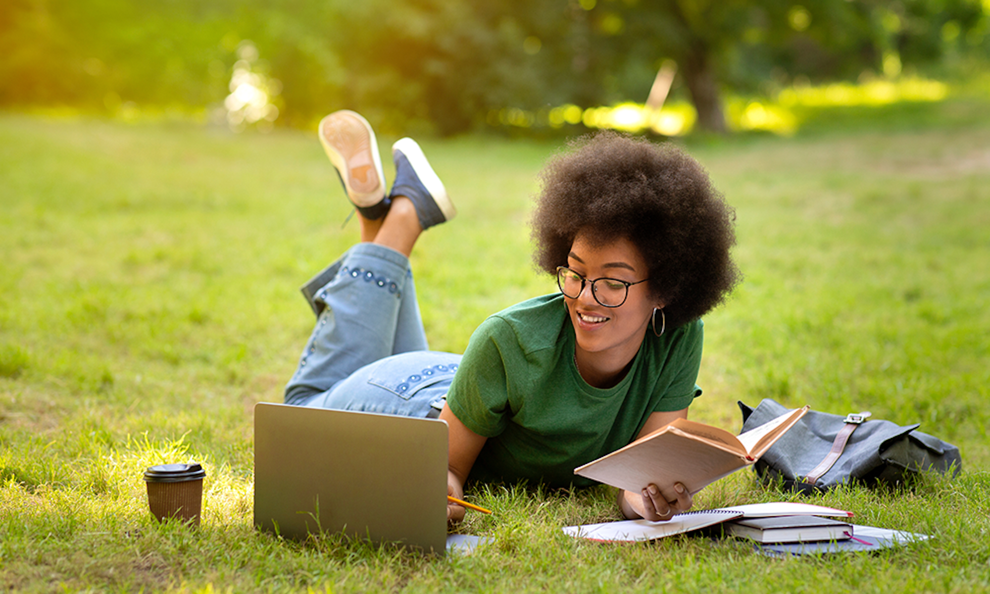Student Laying On Grass Studying
