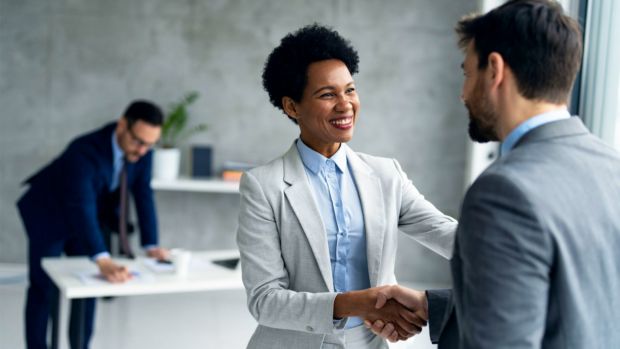 Male and Female colleagues shaking hands smiling