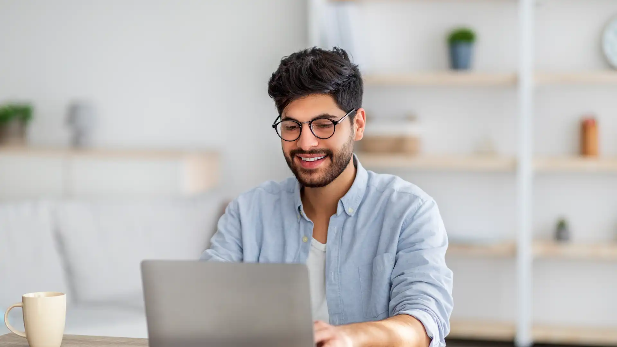 Male man with glasses working on laptop at home