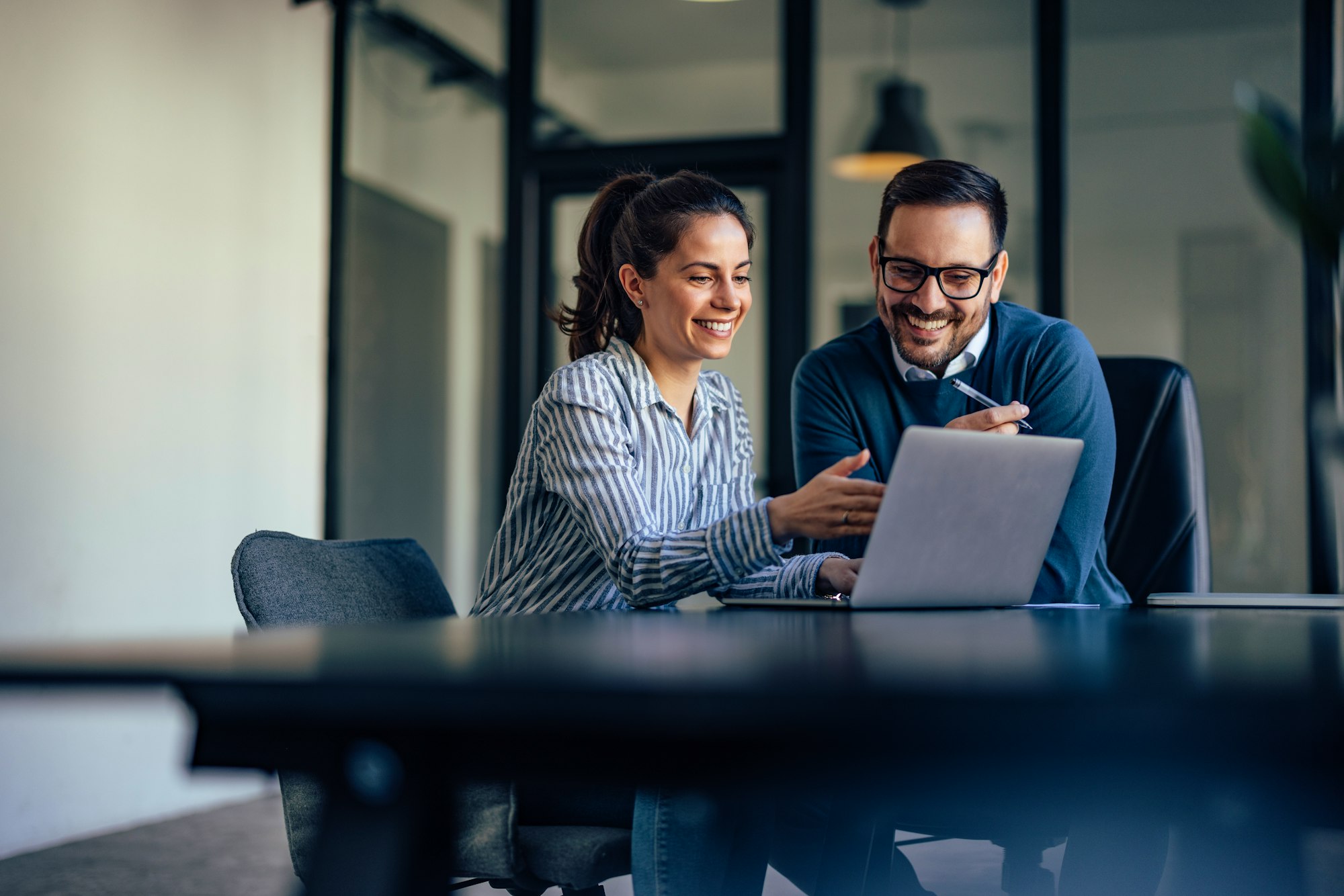 Two People Smiling At Chatbot On Laptop