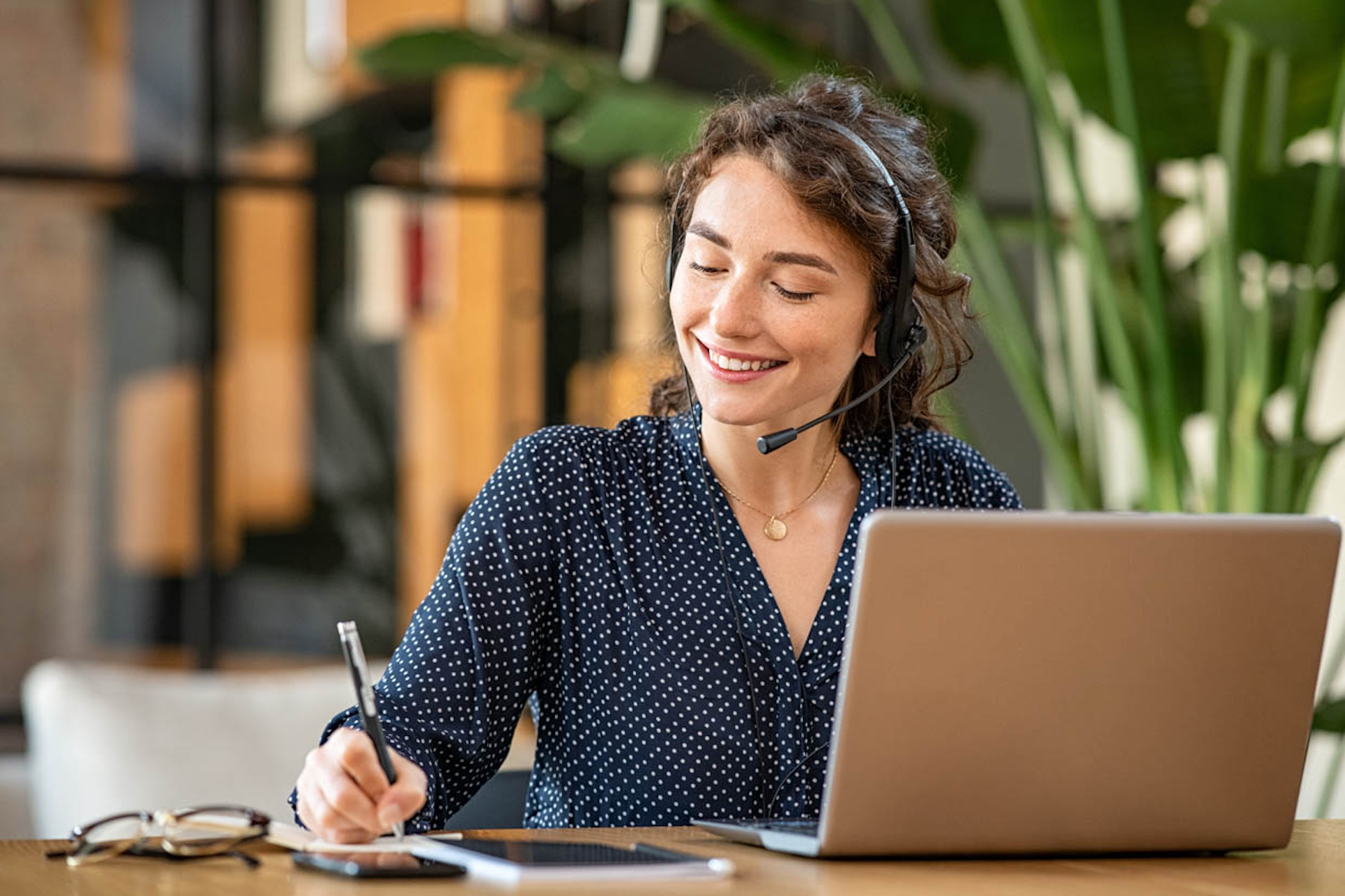Customer service agent with headset and notepad