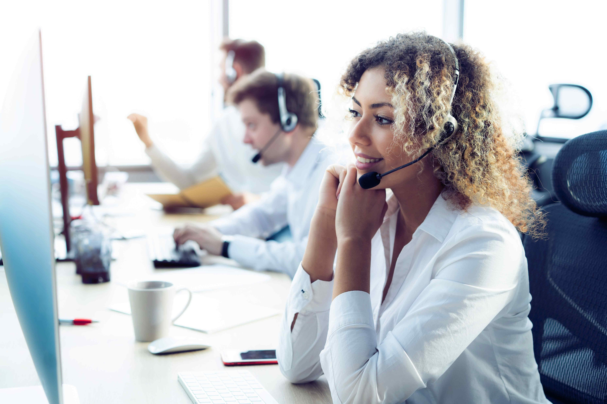 Woman in contact centre with headset on