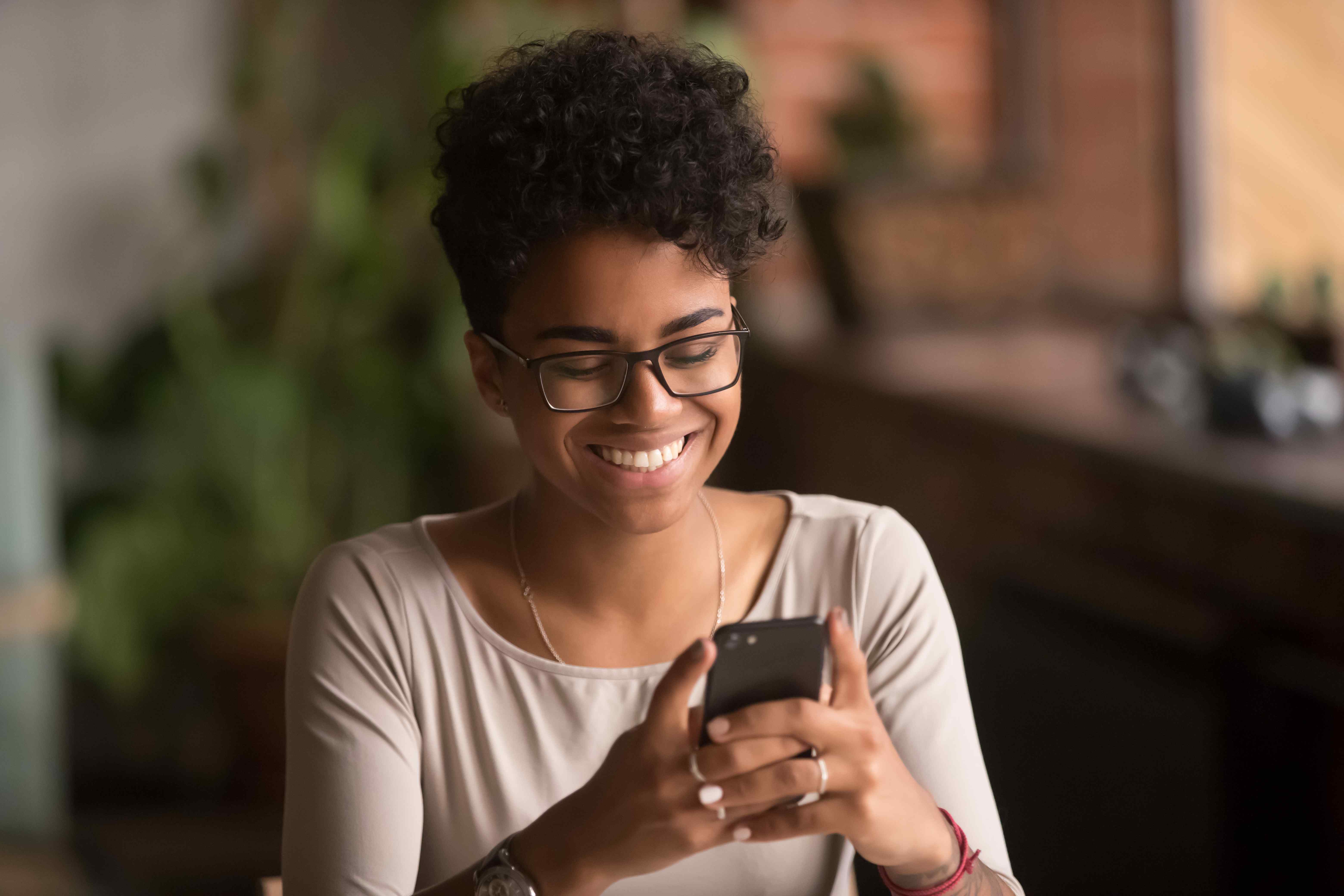 Woman smiling with phone in hand calling into cloud contact centre